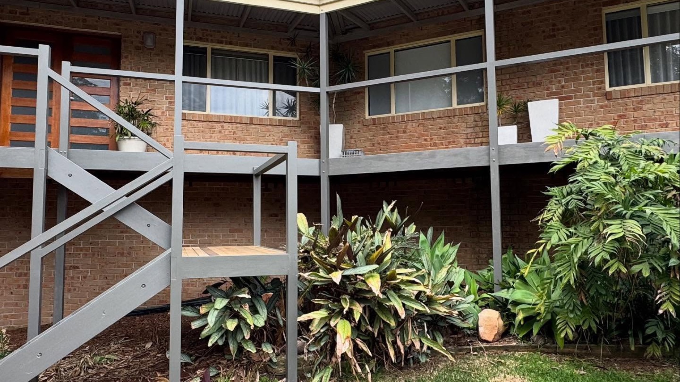 A new timber stair and landing frame going up against a brick home