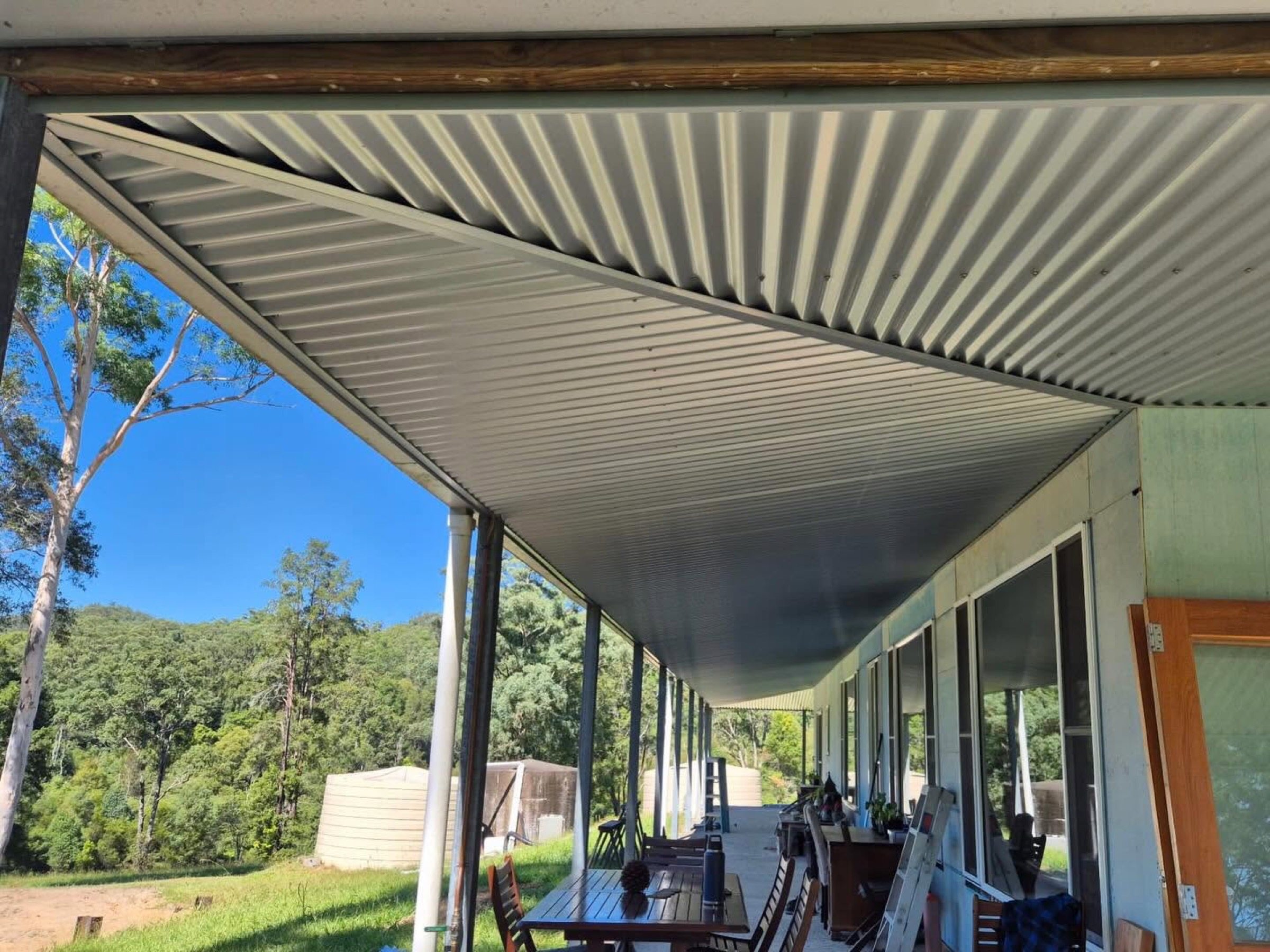 A covered outdoor living area under a new roof looking out to the yard