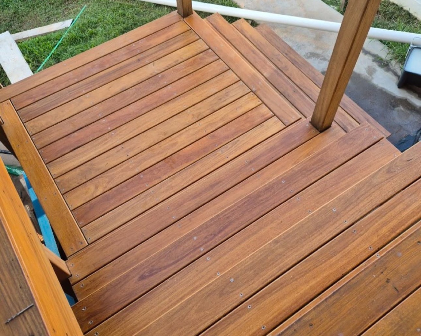 Hardwood decking boards laid tight around a squared timber post