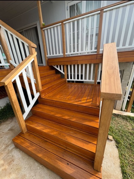 Timber stairs with a white balustrade meeting a deck landing