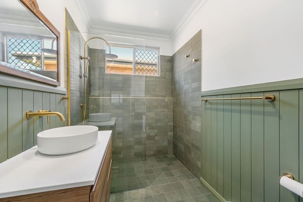 A renovated bathroom with a stone basin and panelled walls