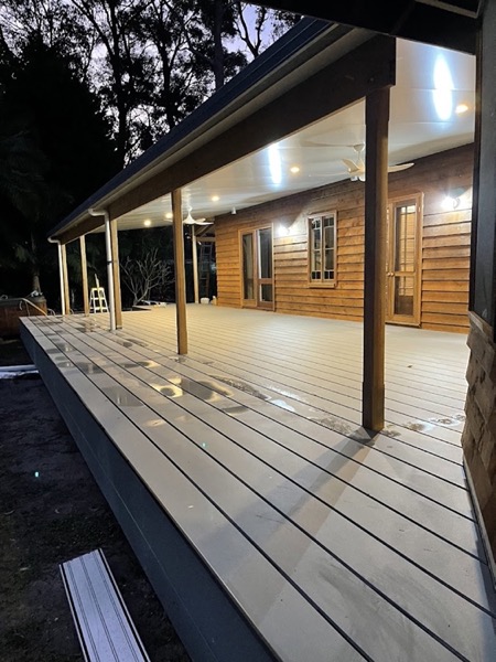 A long deck running along a timber clad home