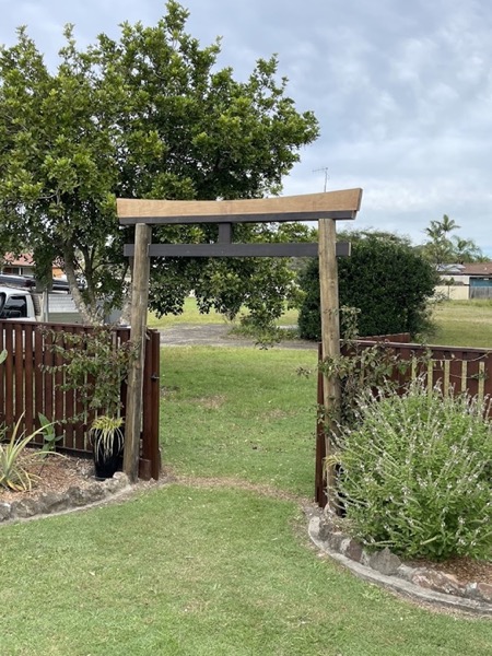 A timber pergola frame standing over a garden path