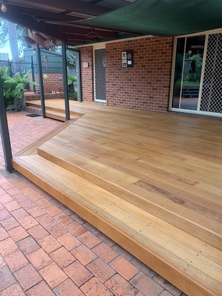 A timber deck with steps down onto brick paving