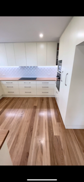 A kitchen with a tiled splashback and timber flooring