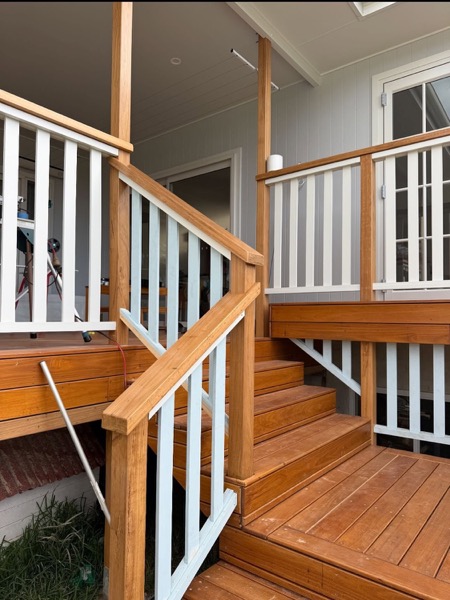 A timber staircase turning at a deck landing