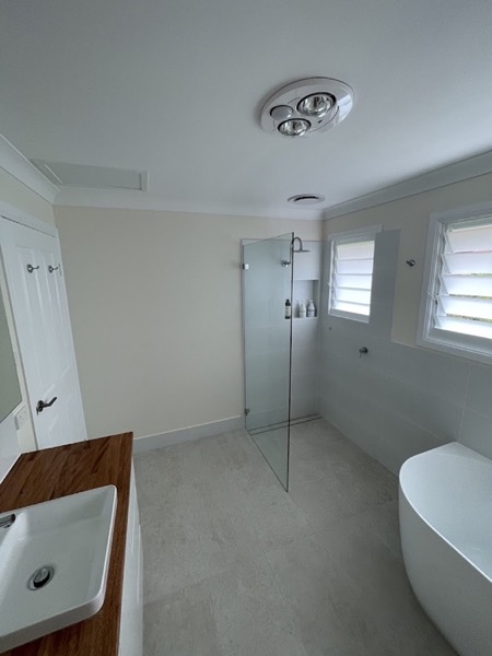 A renovated bathroom with a glass shower screen