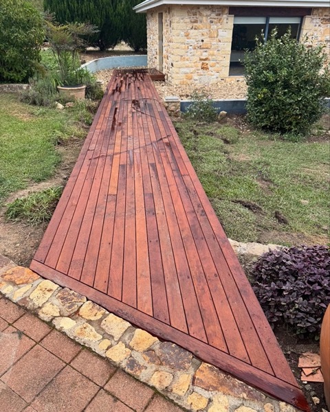 A hardwood walkway running between garden beds