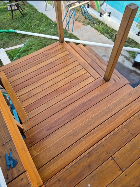 Hardwood deck boards laid tight around a squared timber post