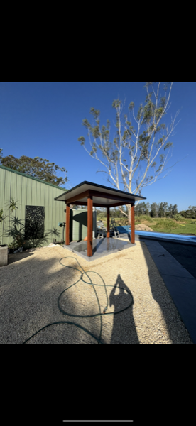 A timber gazebo standing beside a pool