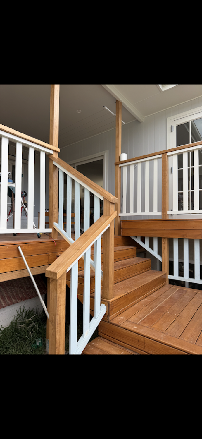 A timber staircase with a white balustrade turning at a landing